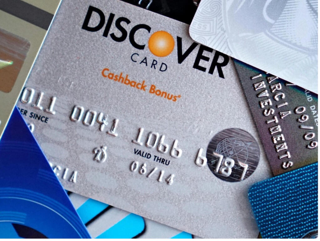 Discover Card credit card with other credit cards representing placing claims on the Discover Card settlement